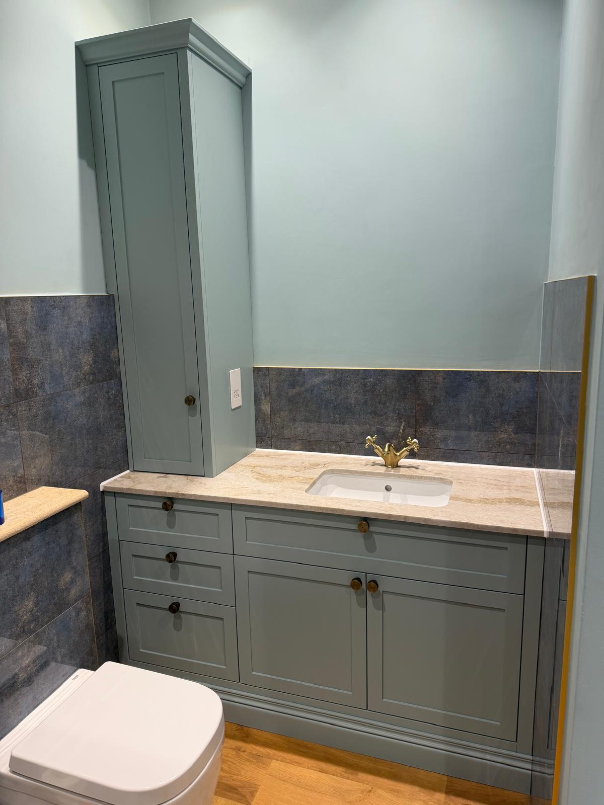 Bespoke fitted bathroom vanity unit in sage green with stone worktop and oak trim
